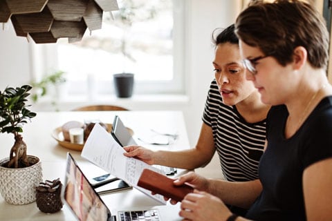 Two women researching paying back taxes